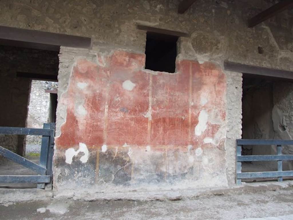 I.12.5 Pompeii. December 2006. Painted wall plaster between two doorways.     I.12.4
High up near the architrave, on the west side (right) of the doorway of I.12.5, a large painted head was found. This showed the personification of Alessandria, or of Egypt, looking straight ahead. Her head was covered with the usual tusks of an elephant.
On the left side of the large painted head, where the stucco is now missing, was a painted Mercury. Mercury (0.56m high) was standing with his caduceus leaning on his left shoulder.
His purse was in his right hand. Many graffiti were recorded from the walls between I.12.5 and I.12.4. See Notizie degli Scavi di Antichità, 1914, (p.181-2)
See Varone, A. and Stefani, G., 2009. Titulorum Pictorum Pompeianorum, Rome: L’erma di Bretschneider. (p.154-5)
