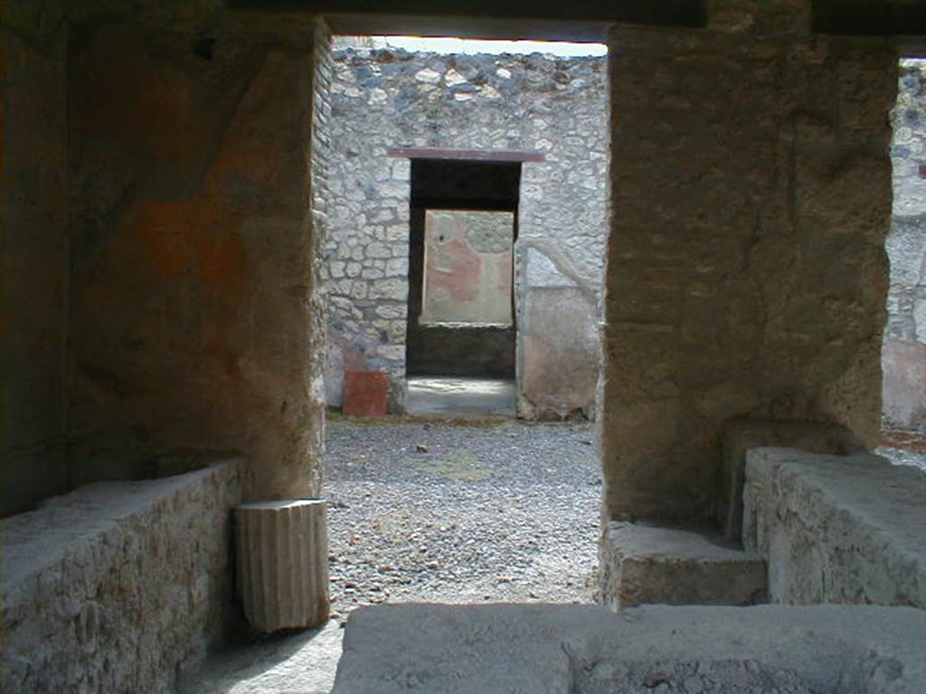 I.12.5 Pompeii. September 2004. 
Looking south through rear of caupona across atrium to doorway to triclinium with window onto garden. 



