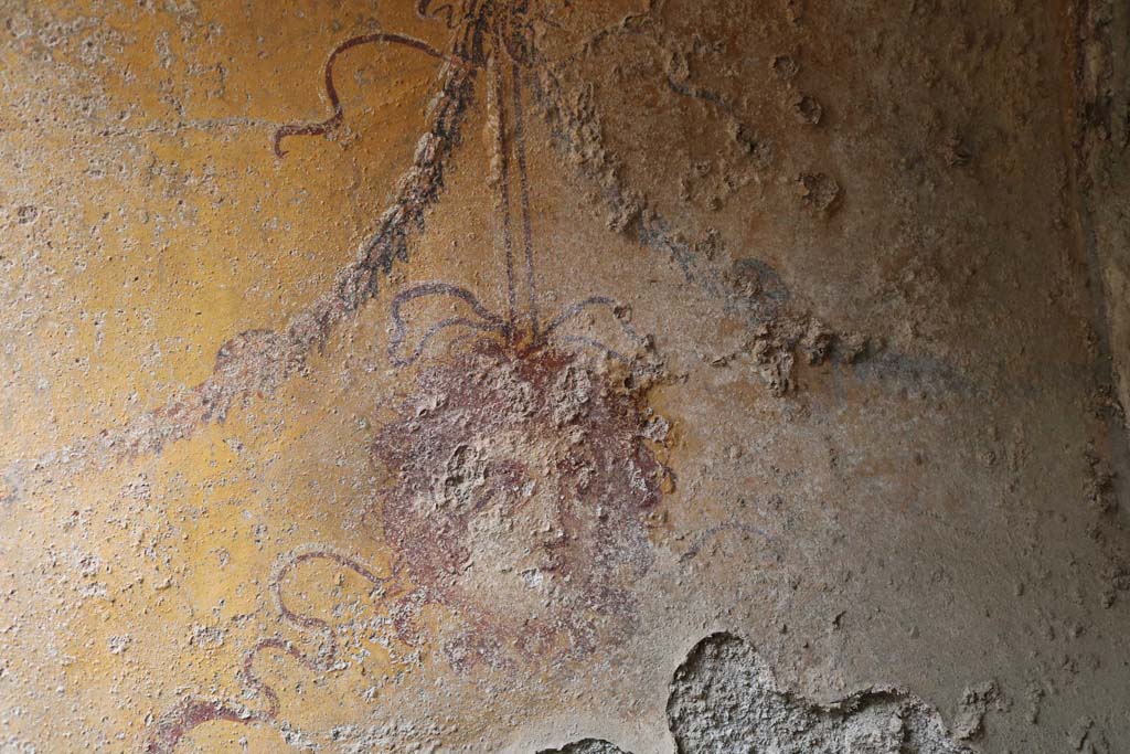 I.12.5 Pompeii. December 2018. North wall of painted Lararium, detail of painted mask. Photo courtesy of Aude Durand.