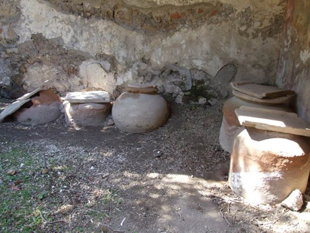 I.12.8 Pompeii. March 2009. Room 9, looking west towards five dolia in north-west corner of peristyle garden.