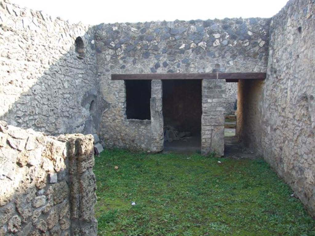 I.12.9 Pompeii. December 2007. Looking south across atrium from tablinum area, towards entrance, on right. On the left can be seen the niches in south-east corner of atrium, as well as a doorway and window to the triclinium. According to Wallace-Hadrill, this room had faded but elegant white-ground style-III decorations. See Wallace-Hadrill, A. (1994). Houses and Society in Pompeii and Herculaneum. Princeton Univ.Press, (p.196/7)
