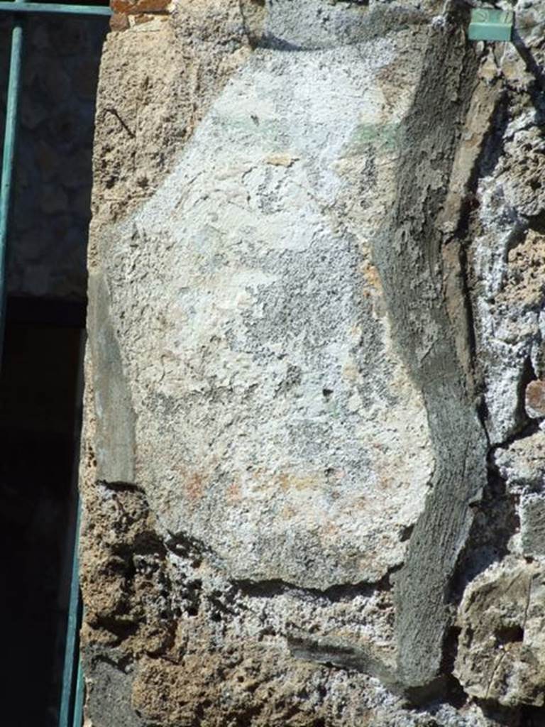 I.12.11 Pompeii. March 2009.  Remains of painted plaster on east side of doorway, which was the site of the wall painting of Hercules. The remains of the garland are just visible.

