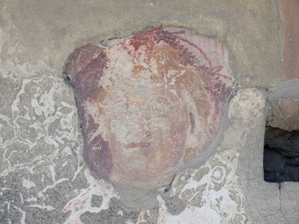 I.12.15 Pompeii. March 2009. Room 5, lararium.  Detail of a face on north side of the niche on the east wall.
