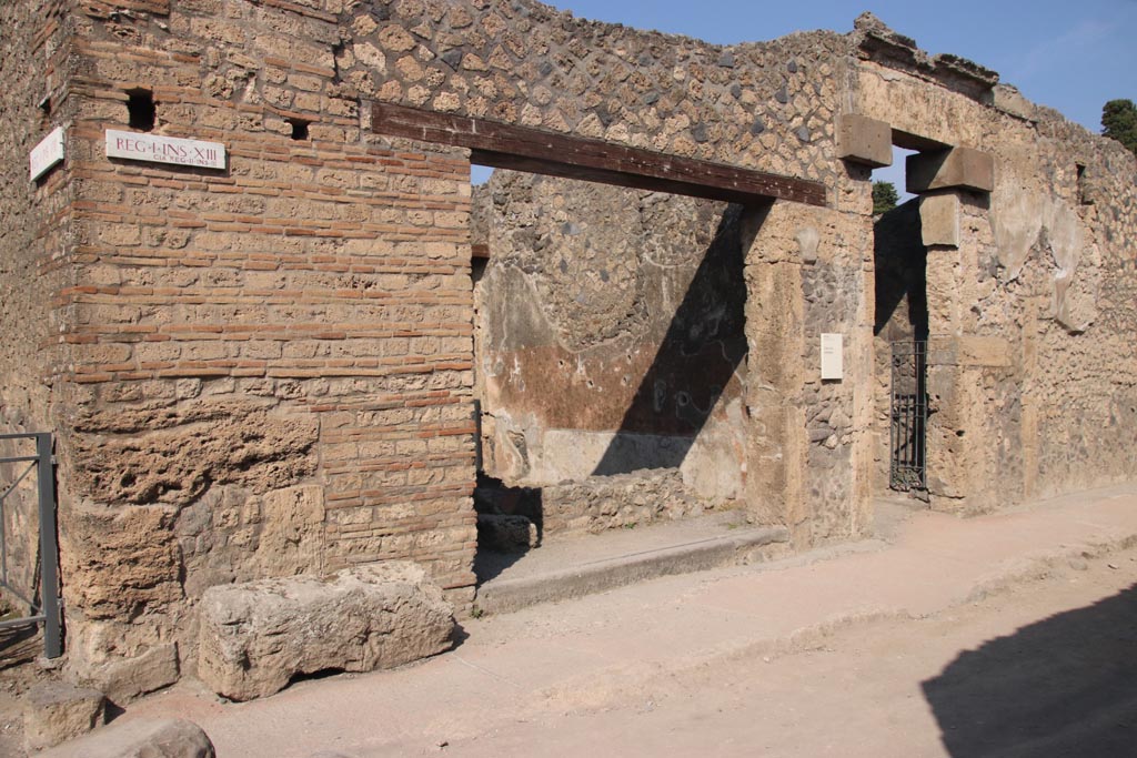 I.13.13 Pompeii, in centre, and I.13.12, on right. October 2023. 
Looking towards entrance doorways on north side of Via di Castricio. Photo courtesy of Klaus Heese.
