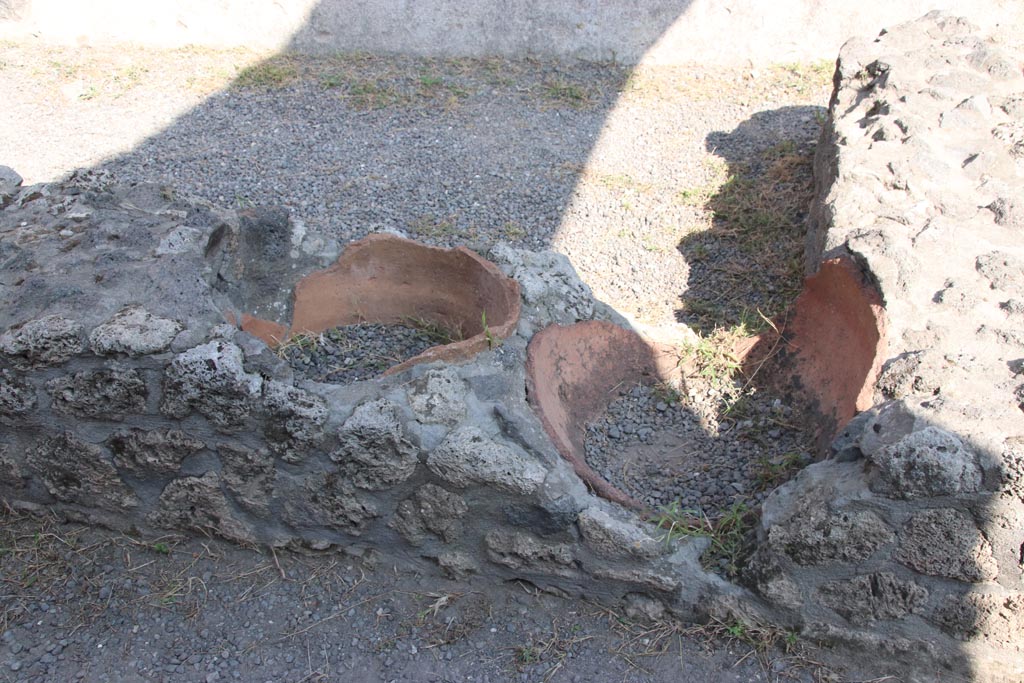 I.13.13 Pompeii. October 2023. Remains of terracotta dolia embedded into counter/podium. Photo courtesy of Klaus Heese.