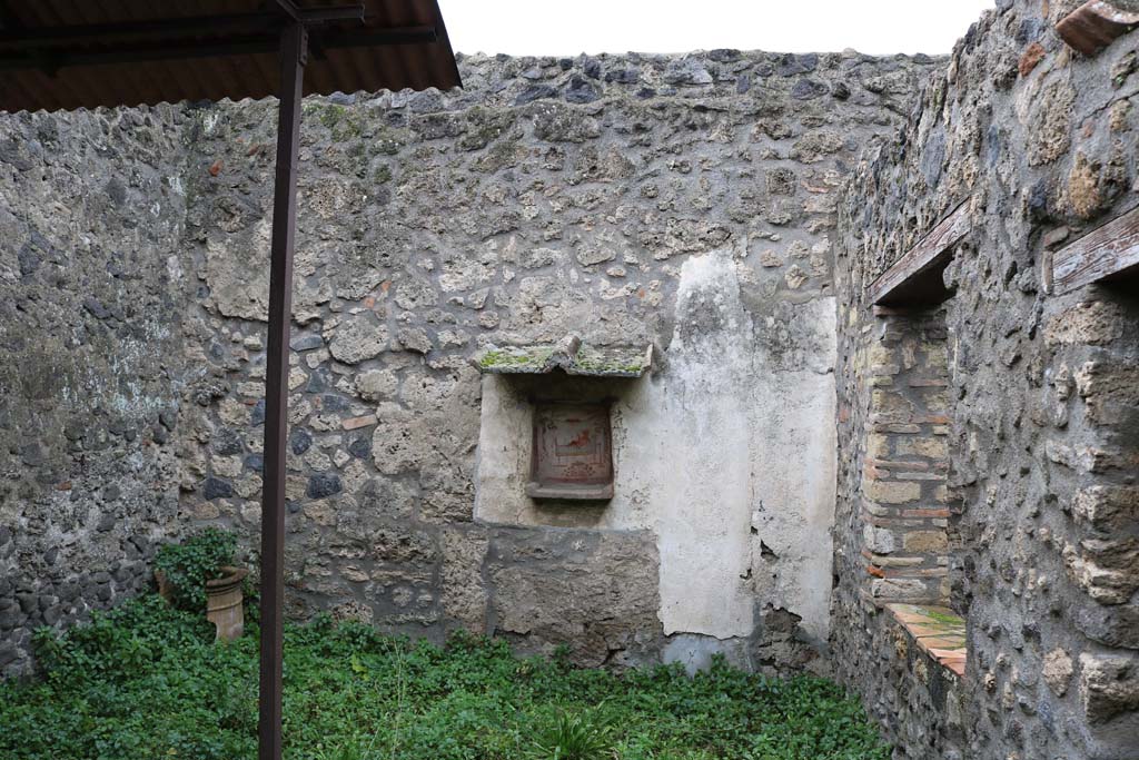 I.14.7 Pompeii. December 2018. Looking towards west wall of the garden area with a niche lararium. Photo courtesy of Aude Durand.