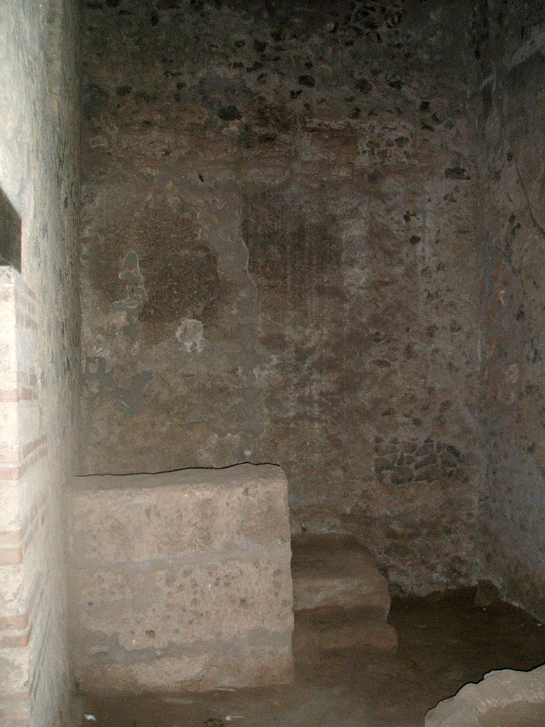 I.15.3 Pompeii. December 2004. 
Room 9. Kitchen looking west to steps to upper floor. The doorway to the latrine is on the left.
