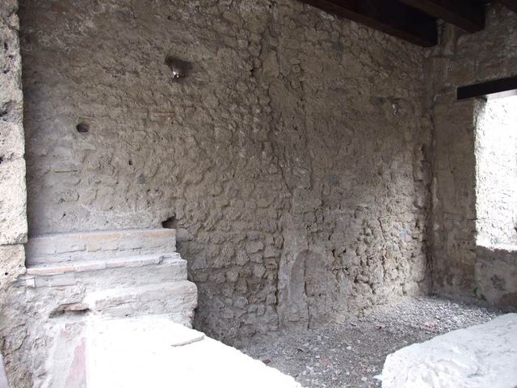 II.1.1 Pompeii. December 2006. Counter and east wall. 
In the south-east corner there was a niche of a lararium to Venus which is no longer visible.
In the 1917 photo of the entrance when first excavated, see above near beginning of photos, the niche can clearly be seen.
See Spinazzola in Notizie degli Scavi di Antichità, 1917, (p.252, fig.5)
According to Boyce, the arched niche on the east wall had a painted blue border. 
In front of it stood a small table decorated with metopes.
Nothing was found in the niche, but when the soil under the niche was investigated, fragments of a pseudo-alabaster statuette of Venus was found.
It was of very rough workmanship but had been gilded originally. 
In front of the image of the goddess stood a small altar of terracotta.
See Boyce G. K., 1937. Corpus of the Lararia of Pompeii. Rome: MAAR 14. (p. 30, no. 61)
Boyce gives a reference to Not. Scavi 1917, 251, with a photograph of the statuette, on p. 253.



