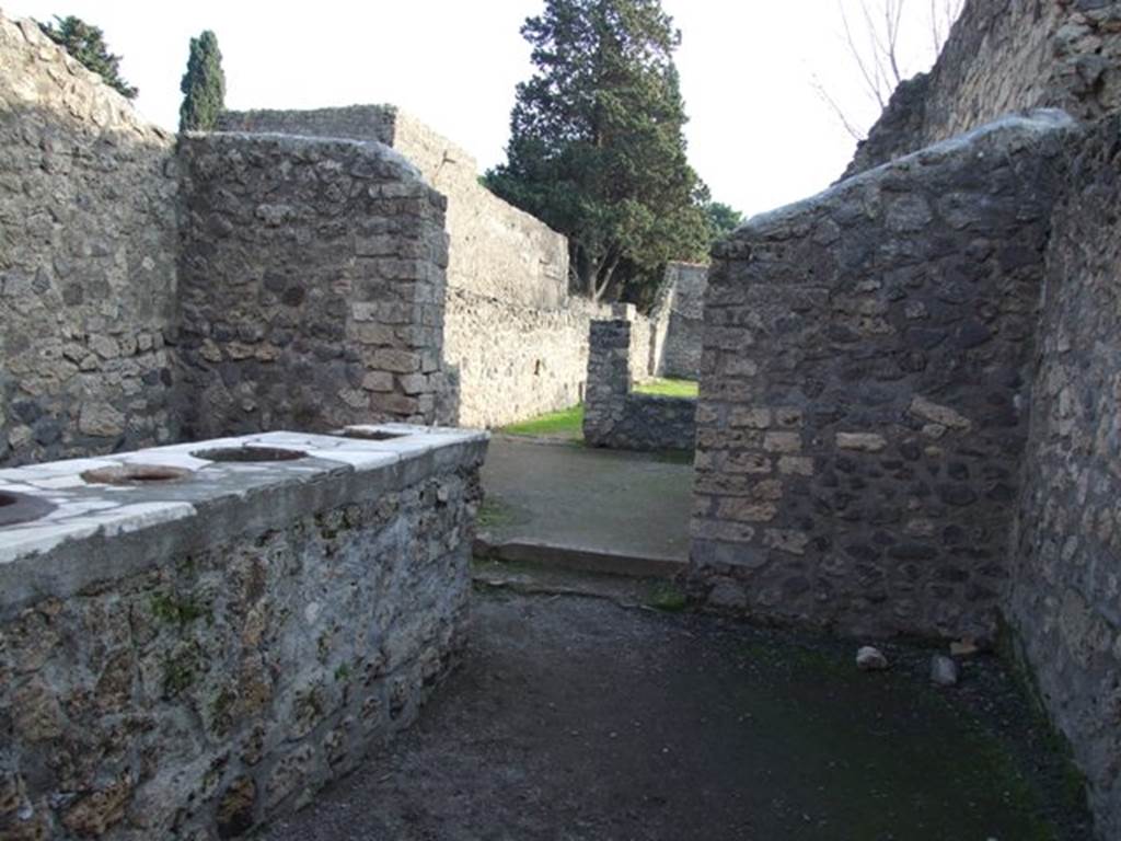 II.1.6 Pompeii. December 2007. Looking south in bar-room into rear room and through window of rear room into garden at II.1.7.
