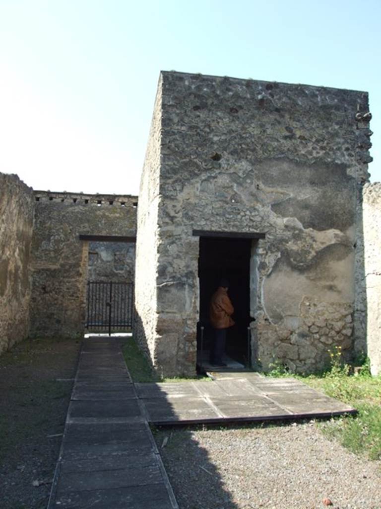 II.1.12 Pompeii. March 2009. Looking west to fauces to front entrance and triclinium on north side. The atrium used to be on the east side of this area (forefront of photo). The plaster still remaining on the wall would have been on the west wall of the atrium. 
