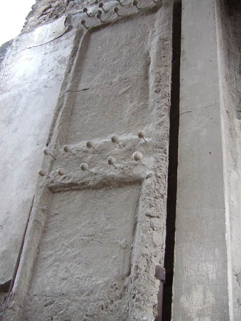 II.2.2 Pompeii. December 2005. Cast of doorway shutter on west side with studs. 
Both shutters were decorated with protruding studs of bronze and iron.

