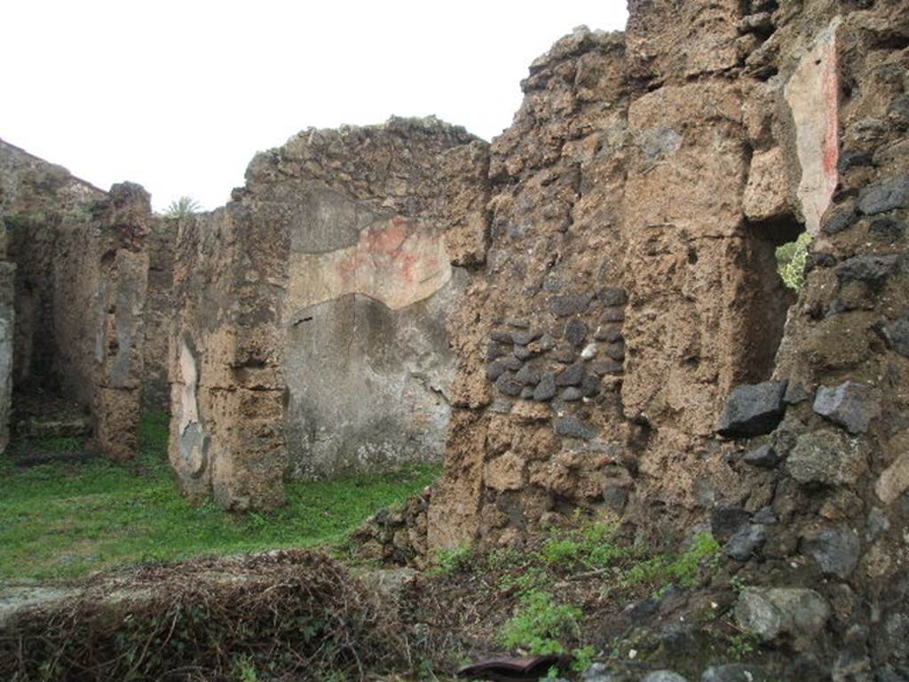 II.3.4 Pompeii. December 2004. Looking east across atrium from side road.
On the left are the steps to upper floor, and doorway into triclinium on the west side of the entrance corridor or fauces. In the centre, with the remains of painted plaster wall decoration is the west wall of the rear room of II.3.5. Originally this rear room would have been connected by doorway to the north-east corner of the atrium. 
