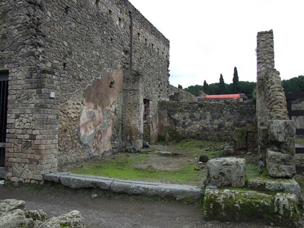 II.4.1 Pompeii. December 2004. Shop entrance, looking south to rear room.
On the west side (right of picture) were the remains of a street shrine, Ara Compitales.
