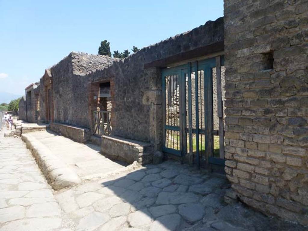 II.4.4 Pompeii. June 2012. Looking east along front façade of insula, with doorway and ramp to II.4.4, on right. Photo courtesy of Michael Binns.
