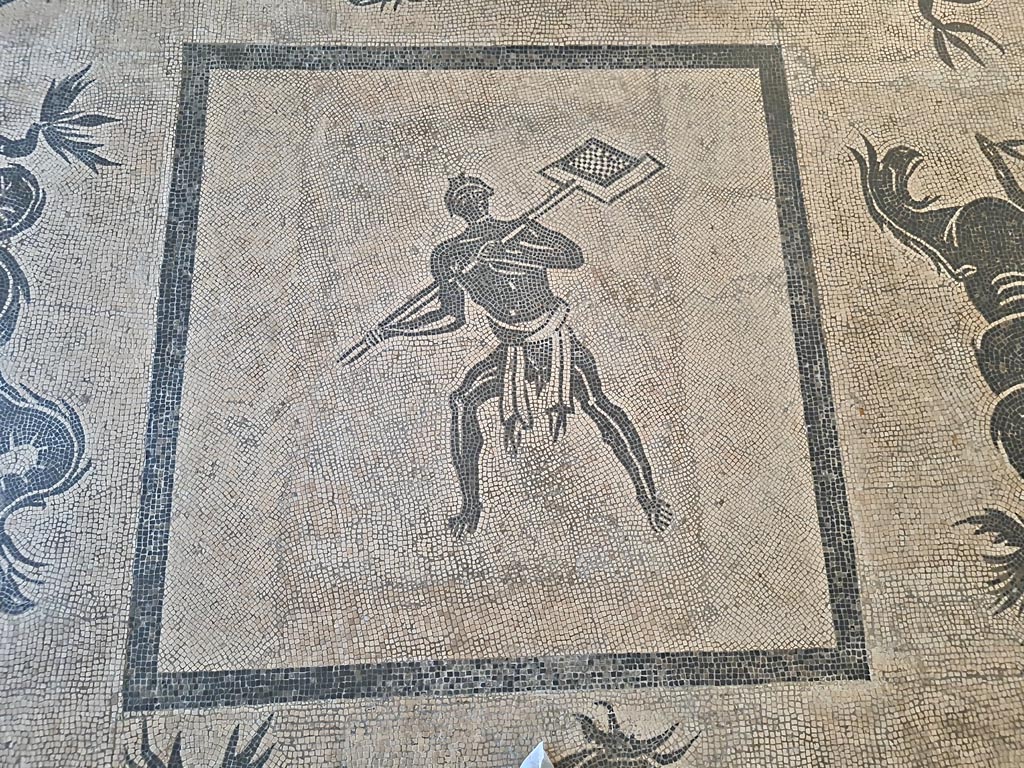 II.4.6 Pompeii. June 2024.   
Black and white mosaic from centre of floor showing a furnaceman and a marine scene set in floor of Naples Museum.
Photo courtesy of Giuseppe Ciaramella.
