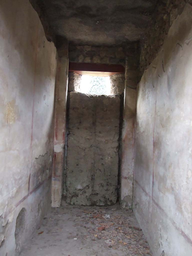 II.4.10 Pompeii. December 2006. Room with blocked door.
When the entrance onto the western roadway was walled up, the wooden door was left closed from the inside.
From this, it was possible to make a mould of the door, and from this it could be seen that it would have had double doors.
