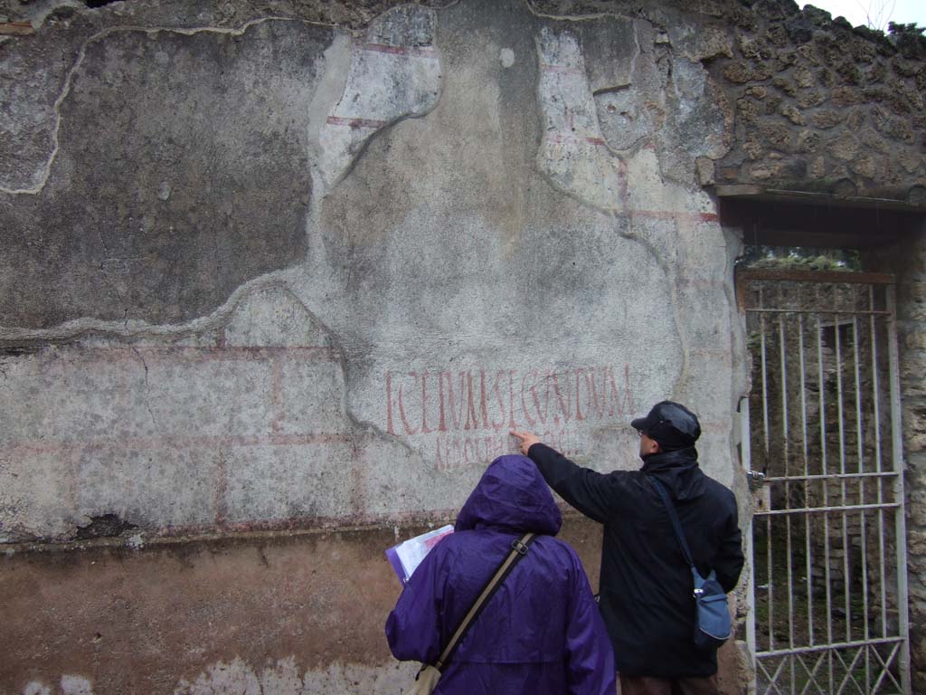 II.4.10 Pompeii. December 2005. Exterior west wall on north side of doorway, showing multiple layers of graffiti or painted plaster.