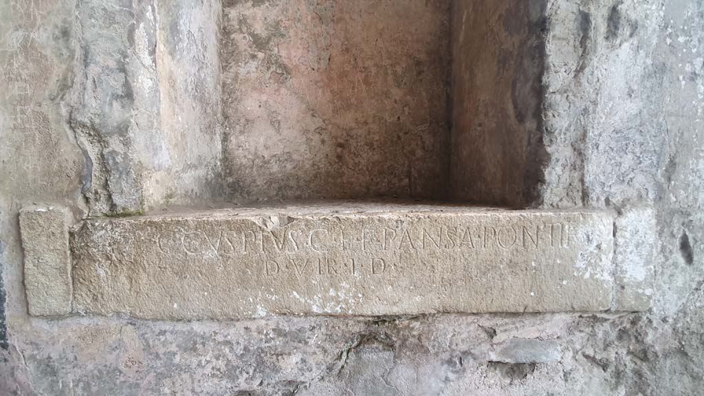 II.6 Pompeii. December 2006. Inscription from west side of corridor of Amphitheatre. The inscription reads –
C. CVSPIVS C. F. PANSA PONTIF.
D. VIR I. D.
One of two inscriptions to father and son, Cuspius Pansa.  
They restored the Amphitheatre at their own expense after the earthquake of AD62.
According to Pagano and Prisciandaro, this read –
C(aius) Cuspius C(ai) f(ilius) {F} Pansa pontif(ex)
d(uum) vir i(ure) d(icundo)    [CIL X 859]
See Pagano, M.  and Prisciandaro, R., 2006. Studio sulle provenienze degli oggetti rinvenuti negli scavi borbonici del regno di Napoli.  Naples : Nicola Longobardi. (p.110)


