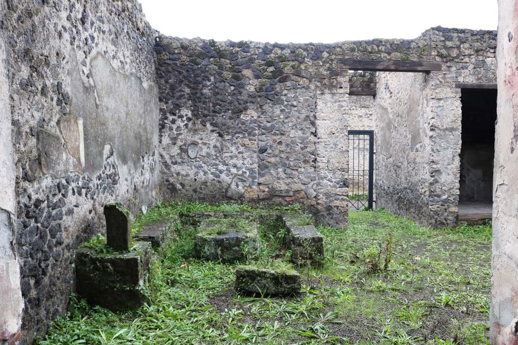 II.8.5 Pompeii. December 2018. 
Looking west towards three-sided stone bench and table in south-west corner of atrium area. Photo courtesy of Aude Durand.
