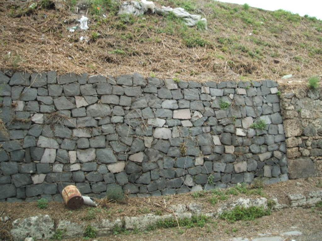 IV.1.b and IV.1.c Pompeii. May 2005. Site of entrances.

The doorways that used to front onto the northern side of Via Nola, forming Regio IV, have now been filled in as a wall to keep the earth bank back from the road.  It is very difficult to find the exact position of these doorways and link them to any site plan.