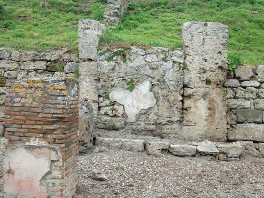 IV.2.a  Pompeii. March 2009. Remains of painted plaster on west side of entrance, at the rear of the portico.