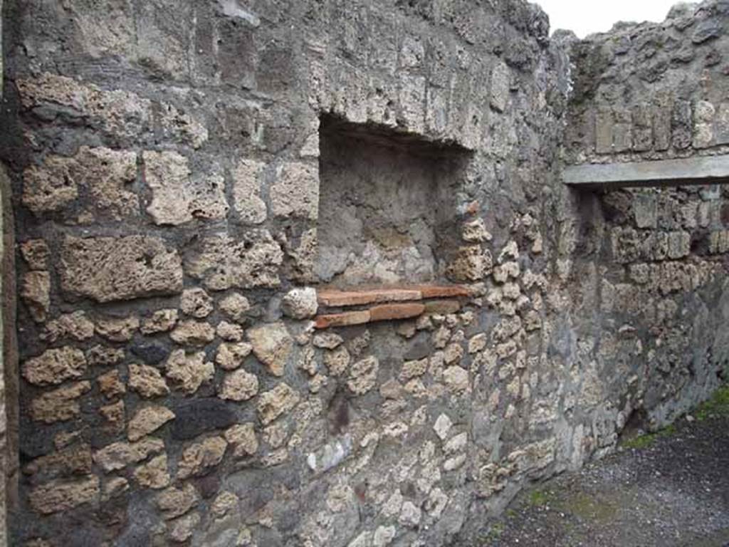 V.1.5 Pompeii. May 2010. West wall with square niche, and door to rear room.