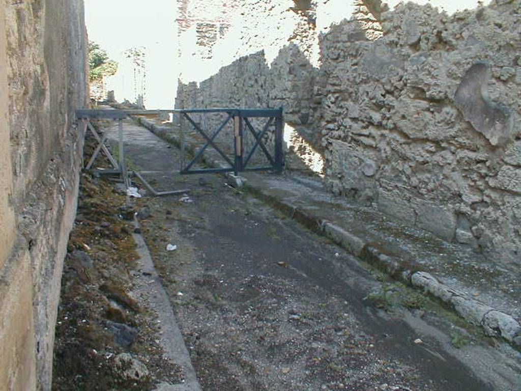 V.1.8 side wall, Pompeii. September 2004. Vicolo di Cecilio Giocondo, looking north.              V.2.