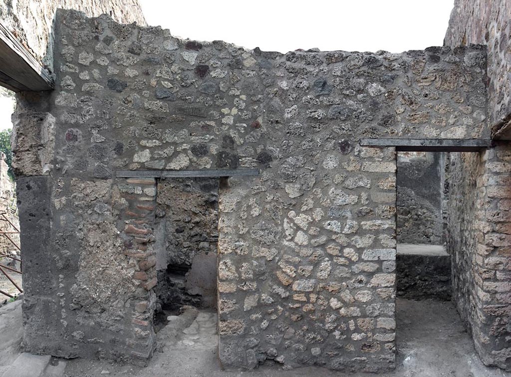 V.1.11 Pompeii. c.2005-7? 
Room “w”, east wall with doorway to latrine (“z”), on left, and to kitchen (“t”) on right.
Photo by Hans Thorwid.
Photo courtesy of The Swedish Pompeii Project.
