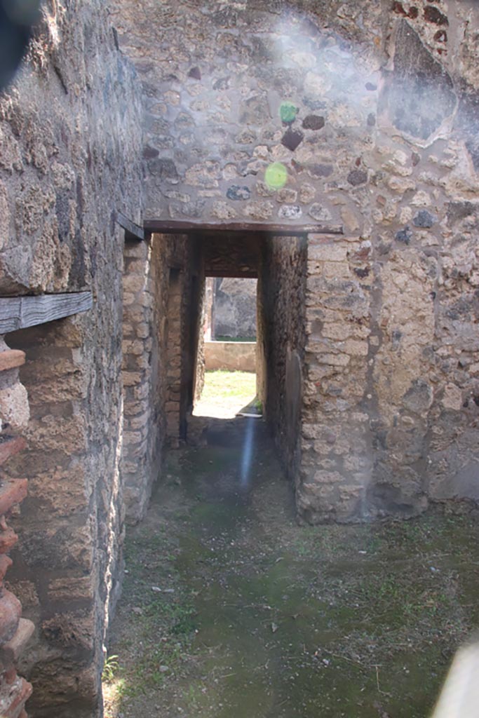 V.1.11 Pompeii. October 2023. 
Looking south from entrance doorway towards doorway into corridor leading into V.1.18 peristyle.
Photo courtesy of Klaus Heese.
