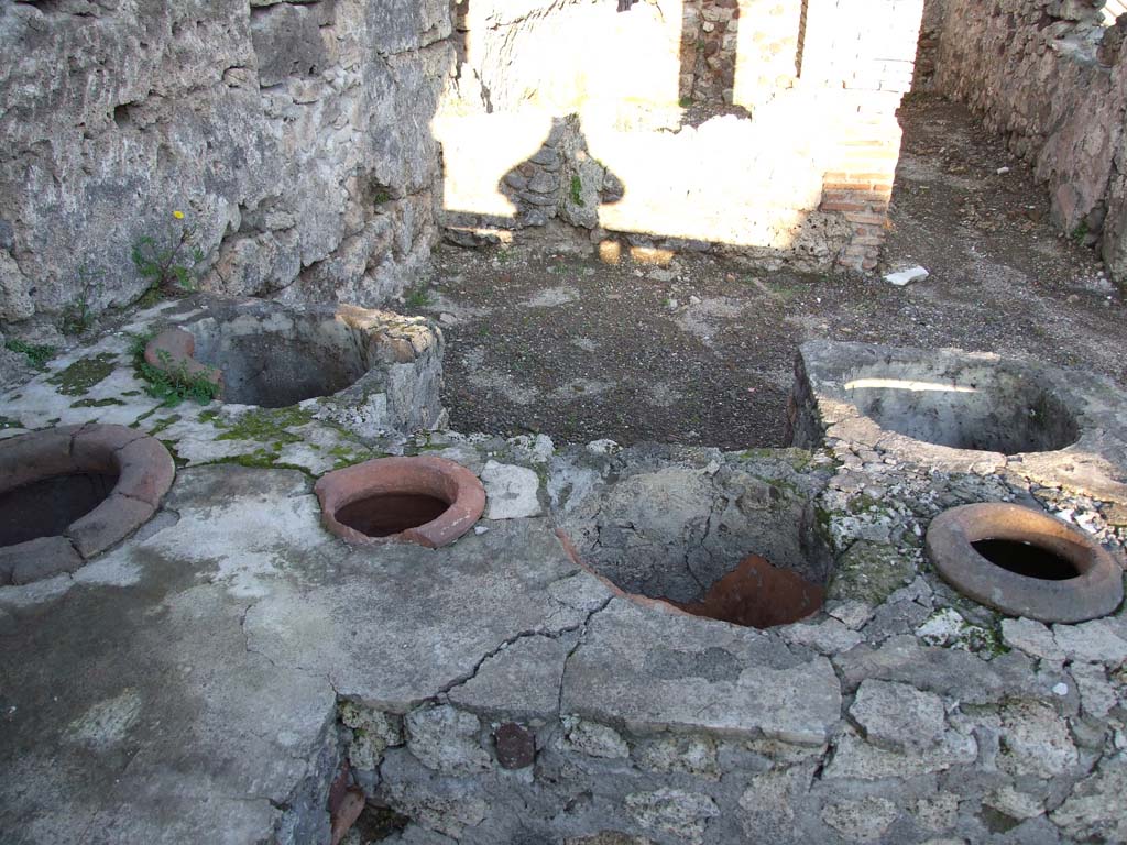 V.I.13 Pompeii. December 2006. Looking east across counter with remains of 6 urns.