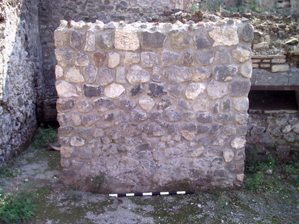 V.1.15 Pompeii. September 2009.  Looking south at east end of oven.
The doorway to the kitchen and latrine in the south-east corner of the bakery is on the left. Photo courtesy of Jared Benton.
According to Boman and Nilsson –
“This room is a rectangular room with a single entrance facing the peristyle-viridarium area.
Based on the installations found inside the room, it presumably served as a combined kitchen and toilet.
The doorway has a lava threshold for a door opening inwards.
Features in the room are a latrine with cess pit, a hearth (presumably of earlier date) and in the SE corner, a narrow quarter-circular bench.”
See The Swedish Pompeii Project (room i)

