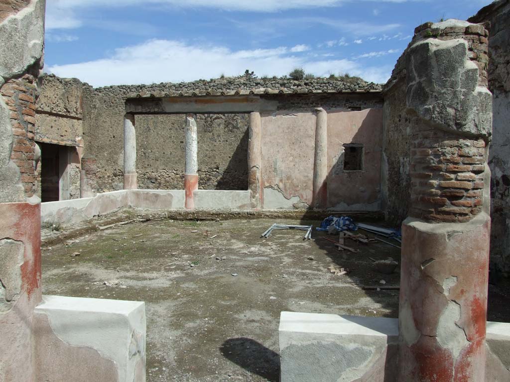 V.1.18 Pompeii. March 2009. Peristyle “i”, looking east from tablinum “g”.
According to Jashemski, the peristyle had a portico on the west, north and part of the east sides.
It was supported by nine columns and two-engaged stucco-covered brick columns.
The columns were red below, and white above, and were connected by a low wall.
The entrance to the garden was on the west side.
The garden painting on the east side was visible from the entrance.
See Jashemski, W. F., 1993. The Gardens of Pompeii, Volume II: Appendices. New York: Caratzas. (p.108, no.165)
