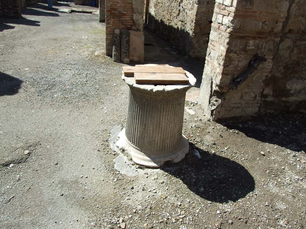 V.1.23 Pompeii. March 2009. Room “l” (L), marble puteal of the cistern in courtyard garden area. 
On the wall to the right can be seen the remains of a large lead pipe that fed the cistern with rainwater from the roof.

