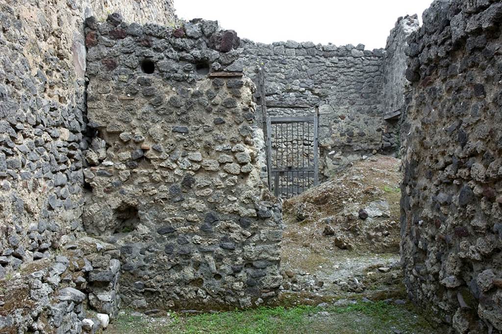 V.1.23 Pompeii. 
Room “q”, east wall, with doorway into kitchen and towards rear doorway at V.1.10. Photo by Hans Thorwid.
Photo courtesy of the Swedish Pompeii Project.

(See V.1.10 for extract from BdI, 1876 referring to this area)
