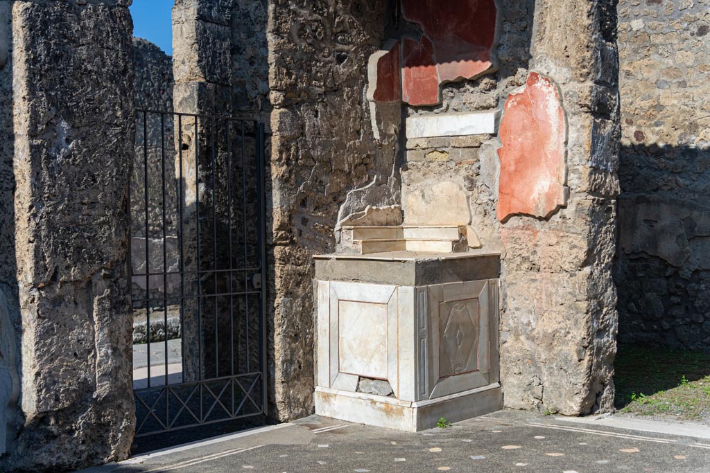 V.1.26 Pompeii. October 2023. Room b, north-west corner of atrium with marble lararium. Photo courtesy of Johannes Eber.

