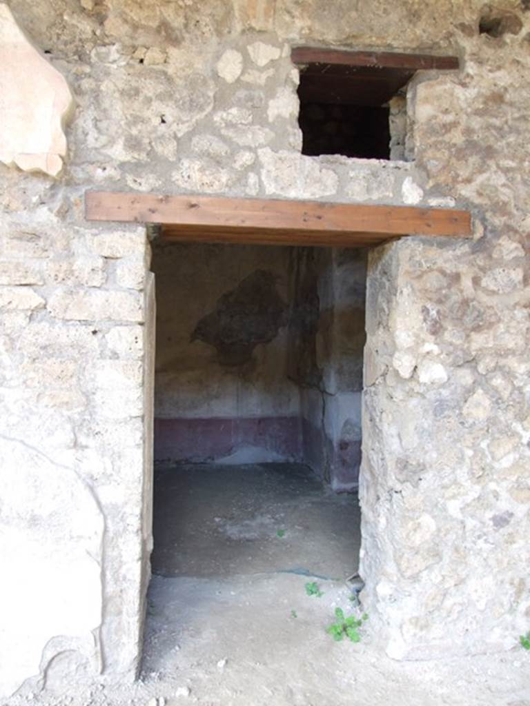 V.1.26 Pompeii. March 2009. Room p, doorway to room on east side of triclinium.
A picture of Dionysus, standing, holding a thyrsus, was in the central panel of the bed alcove against the east wall, a rare occurrence.

