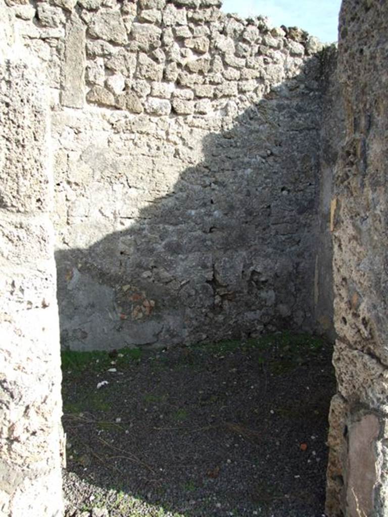 V.2.7 Pompeii. December 2007. Doorway to room 8, room on east side of atrium.
Mau wrote 
This room was a pantry, with shelves on the walls, which were covered with rough/raw plaster.
This room would have been decorated in the IV Style on a simple white background.
Found in this room was a large weight of travertine.  
In this room (8 or "k") the bed was hanging from the right wall; to enlarge the place the stucco had been removed from the relative part of the entrance and back walls (instead of making the usual recesses).
(BdI, 1894, p.40).
According to PPM, 
On the south wall, the zoccolo was edged with a green border, the middle zone was divided into two panels with purple carpet border edging with rectangles divided by diagonals, separated by a yellow border.
