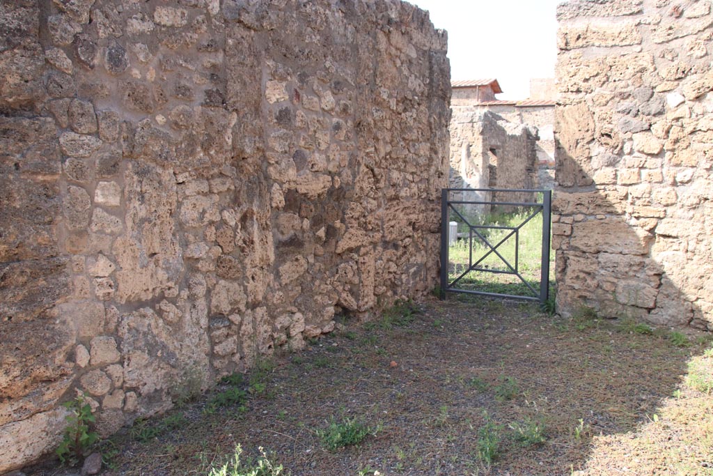 V.2.11 Pompeii. October 2023. 
Looking north along west wall of shop-room, towards doorway into V.2.10 in north-west corner. Photo courtesy of Klaus Heese.
