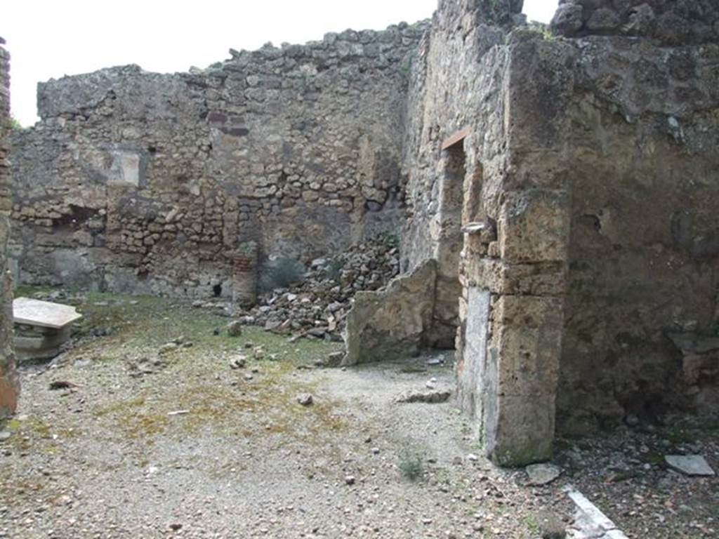 V.2.15 Pompeii. March 2009. Looking west across north side of peristyle. The doorway to room 8, exedra, is on the right. In the centre right, is the doorway to room 9, the kitchen.
