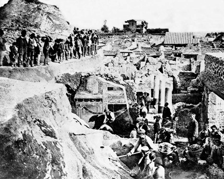 V.2.15 Pompeii. Late 19th century photograph showing excavation, (c.1896).
Looking south from south-east corner of V.2.i, across the columns of the peristyle garden of Casa di Orione/V.2.15, towards the rear of the Casina dellAquila in the distance. 
In the centre front, the second style decoration on south wall of Corinthian oecus, room 21 of The House of the Silver Wedding at V.2.i can be seen.
Photo courtesy of Rick Bauer.
