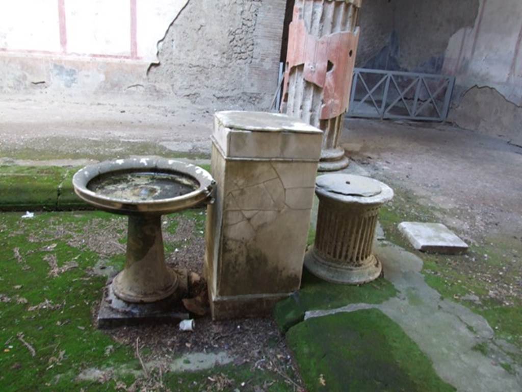 V.2.i Pompeii. December 2007. Room 1, atrium, south end of impluvium.  
Looking east towards stone basin on a stand with a bronze water spout next to a rectangular marble base and a travertine puteal.


