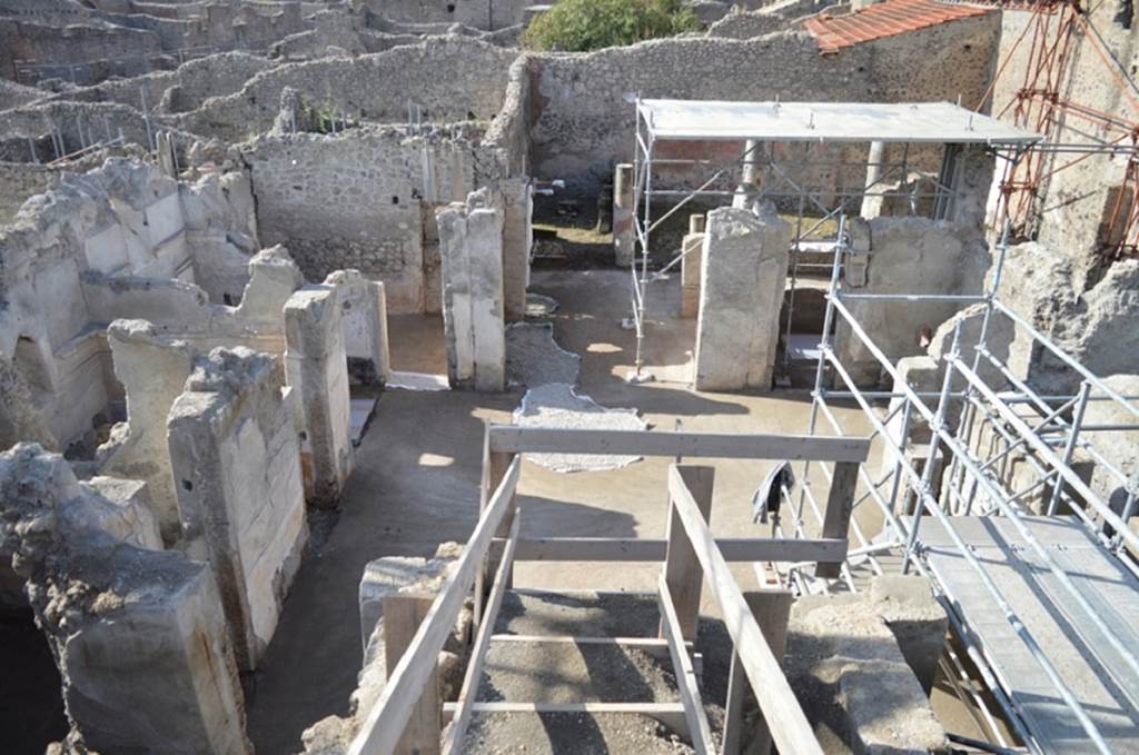 V.2.Pompeii. Casa di Orione. August 2018. Looking west across atrium A12.
On the west side are the doorways to rooms A8, A7 and A6.
On the south side (left) are doorways to rooms A17, A11 and A13. On the east side is room A3, (lower left).
On the north side (right) is the open front of ala room A18 and doors of room A15.
Photograph © Giuseppe Scarica, Ecampania.it.
The atrium was found without an impluvium (testudinate atrium) due to the reconstruction of the roof line which eliminated the central opening. 

