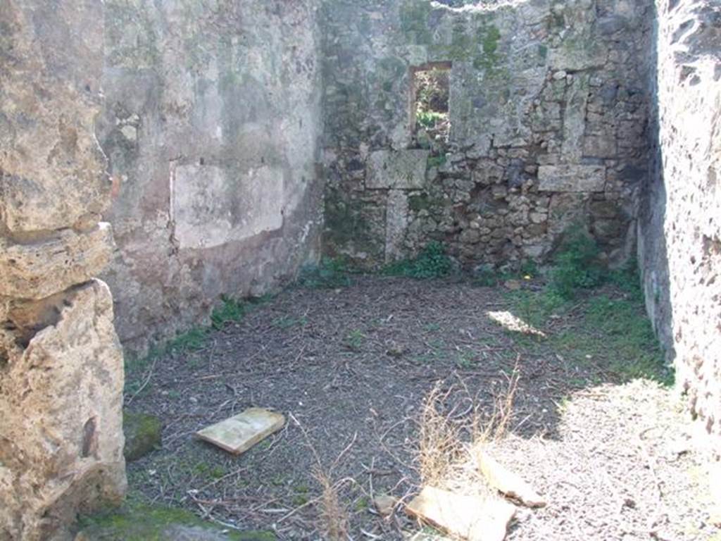 V.3.4 Pompeii. March 2009. Room on west side of portico, Looking west. According to Sogliano, this room had walls lined with rough plaster with a brick plinth. A painting of two pairs of gladiators crudely executed was found on the south wall above the remains of white plaster, at the brick plinth height. The one on the left consisted of a gladiator chasing his opponent. Also found in this room were piles of building materials, which demonstrated that the house was undergoing repairs at the time of the disaster.See Notizie degli Scavi di Antichità, 1905, (p.205)
