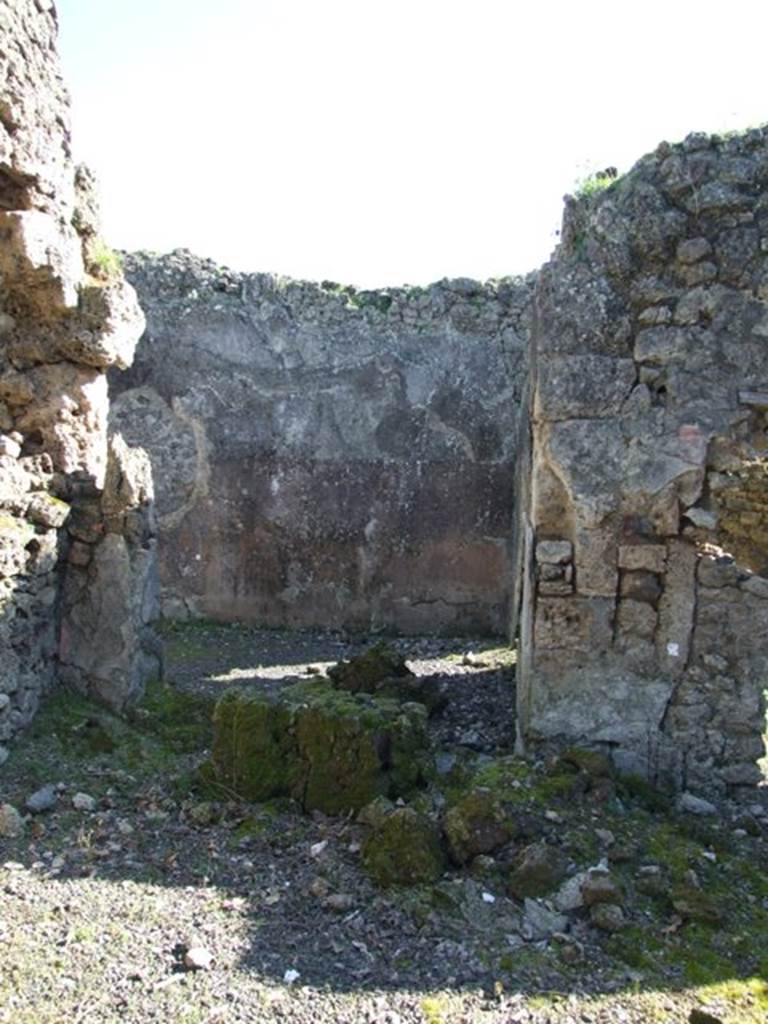 V.3.11 Pompeii. March 2009. Doorway to triclinium, in south-east corner of atrium.
According to NdS, this large room was decorated with a yellow dado separated by bands of imitation variegated marble. In each of the upper panels was a small bronze-coloured painted figurine, sphinx, griffin, peacock, or harpy. In two places the walls were irregularly holed, as occurred many times by those fleeing the eruption or by searchers in the buried city.  For these holes in the walls, a system had now been adopted. If they did not compromise the stability of the wall, they were left as they were, facing only the edges with cement. In the opposite case, they would be blocked up, inserting a marble slab engraved with the year of restoration. See Notizie degli Scavi, 1902, (p.371)
According to Bragantini, the dado was black, and the middle zone was yellow with panels.
See Bragantini, de Vos, Badoni, 1983. Pitture e Pavimenti di Pompei, Parte 2. Rome: ICCD. (p.79, ambiente (C))
