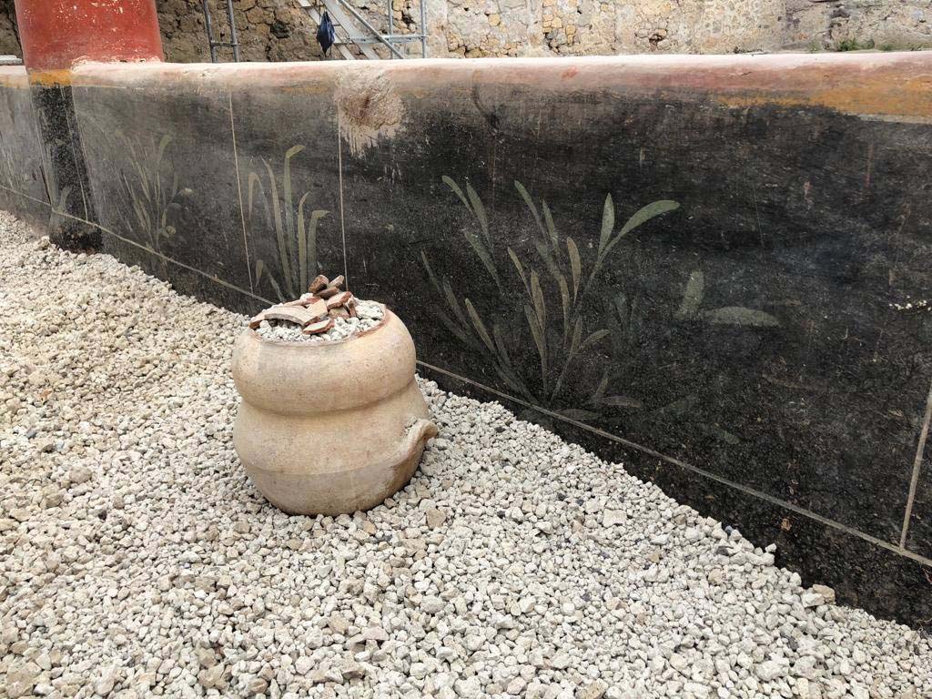 V.3 Pompeii. Casa del Giardino. 2018. The portico has a low black wall with plant decoration and red and white columns.

Il portico ha una parete nera bassa con decorazione vegetale e colonne rosse e bianche.

Photograph © Parco Archeologico di Pompei.
