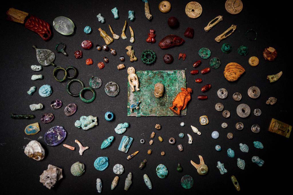 V.3 Pompeii. Casa del Giardino. August 2019. Amulets and gems for personal ornamentation or to protect against bad luck.

Amulets, gems and small objects re-emerge from the excavation of the Regio V. They were related to the female world, used for personal ornamentation or to protect from bad luck. They were found in one of the rooms of the House of the Garden. 

Kept in a wooden box, they have been restored and brought to their former glory by the restorers of the Laboratory of the Archaeological Park of Pompeii. They were probably objects that the inhabitants of the house could not take away before they escaped. The wood of the box has decomposed and only the bronze hinges remain, well preserved under the volcanic material.

Among the numerous objects found, two mirrors, pieces of necklace, decorative elements made of faience, bronze, bone and amber, a glass unguentaria, phallic amulets, a human figure and various gems (including an amethyst with a female figure and a carnelian with a craftsman figure). In a glass paste is engraved the head of Dionysus, on another a dancing satyr. The high quality of the amber and glass pastes and the engraving of the figures confirm the importance of the domus owner.

"They are objects of everyday life in the female world and are extraordinary because they tell micro-stories, biographies of the inhabitants of the city who tried to escape the eruption" - says General Director Massimo Osanna - "In the same house, we discovered a room with ten victims, including women and children, and now we are trying to establish kinship relationships, thanks to DNA analysis. Perhaps the precious box belonged to one of these victims. Interesting is the iconography of objects and amulets, which invoke fortune, fertility and protection against bad luck. And the numerous pendants in the shape of small phallus, or the ear, the closed fist, the skull, the figure of Harpocrates, the scarabs. Symbols and iconographies that are now being studied to understand their meaning and function"

See PAP: The-luck-and-the-protection-against-the-bad-fate-in-the-jewelery-of-regio-v

Amuleti e gemme per ornamenti personali o per proteggere contro la sfortuna.
Amuleti, gemme ed elementi decorativi in faience, bronzo, osso e ambra riemergono dallo scavo della Regio V. Erano monili e piccoli oggetti legati al mondo femminile, utilizzati per ornamento personale o per proteggersi dalla cattiva sorte, ritrovati in uno degli ambienti della casa del Giardino.

Custoditi in una cassa in legno, e da poco restaurati e riportati al loro splendore dalle restauratrici del Laboratorio di Restauro del Parco Archeologico di Pompei, si trattava di una parte dei preziosi di famiglia, che forse gli abitanti della casa non riuscirono a portare via prima di tentare la fuga. La traccia della cassa in legno che conteneva i reperti, le cui cerniere bronzee si sono ben conservate all’interno del materiale vulcanico, a differenza della parte lignea decompostasi, è stata individuata accanto all’impronta di un’altra cassa o mobile nell’angolo di uno degli ambienti di servizio, probabilmente usato come deposito.
 
Sul fondo dell’impronta sono stati rinvenuti i numerosi oggetti preziosi, tra cui due specchi, diversi vaghi di collana, elementi decorativi in faience, bronzo, osso e ambra, un unguentario vitreo, amuleti fallici, due frammenti di una spiga di circa 8 cm e una figura umana, entrambi in ambra, probabilmente dal valore apotropaico, e varie gemme (tra le quali una ametista con figura femminile e una corniola con figura di artigiano). Diversi pezzi si contraddistinguono per la qualità pregiata dei materiali, oltre che per la fattura. Tra le paste vitree, straordinarie sono quelle con incise, su una la testa di Dioniso, sull’altra un satiro danzante.

Alcuni oggetti preziosi sono stati rinvenuti anche in una altra stanza della casa, presso l’atrio, dove sono stati documentati i resti scheletrici di donne e bambini, sconvolti da scavi clandestini di età moderna (XVII – XVIII secolo), probabilmente finalizzati proprio al recupero dei preziosi che le vittime portavano con sé. Solo un anello in ferro, ancora al dito della vittima, e un amuleto di faience sono casualmente sfuggiti a questo saccheggio.

Considerate le straordinarie condizioni di conservazione e la particolare qualità dei manufatti è stato possibile donar loro una nuova vita mediante un intervento di semplice pulitura e consolidamento con materiali reversibili.

“Si tratta di oggetti della vita quotidiana del mondo femminile e sono straordinari perché raccontano microstorie, biografie degli abitanti della città che tentarono di sfuggire all’eruzione. – dichiara il Direttore Generale Massimo Osanna - Nella stessa casa, abbiamo scoperto una stanza con dieci vittime, tra cui donne e bambini, di cui stiamo cercando di stabilire le relazioni di parentela e ricomporre la biografia del gruppo familiare, attraverso le analisi sul DNA. E chissà che la cassetta di preziosi non appartenesse a una di queste vittime. Particolarmente interessante è l’iconografia ricorrente degli oggetti e amuleti, che invocano la fortuna, la fertilità e la protezione contro la mala sorte. E dunque i numerosi pendenti a forma di piccoli falli, o la spiga, il pugno chiuso, il teschio, la figura di Arpocrate, gli scarabei. Simboli e iconografie che sono ora in corso di studio per comprenderne significato e funzione”

See PAP: La-fortuna-e-la-protezione-contro-la-malasorte-nei-monili-della-regio-v

Foto: Cesare Abbate/ANSA courtesy Parco Archeologico di Pompei.
