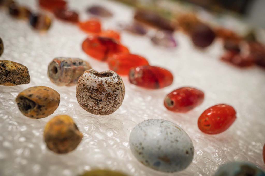 V.3 Pompeii. Casa del Giardino. August 2019. Amber, glass and other gems, apparently part of a necklace.
Ambre, vetri e altre gemme, appartenevano una collana.
Photograph © Cesare Abbate/ANSA courtesy Parco Archeologico di Pompei.
