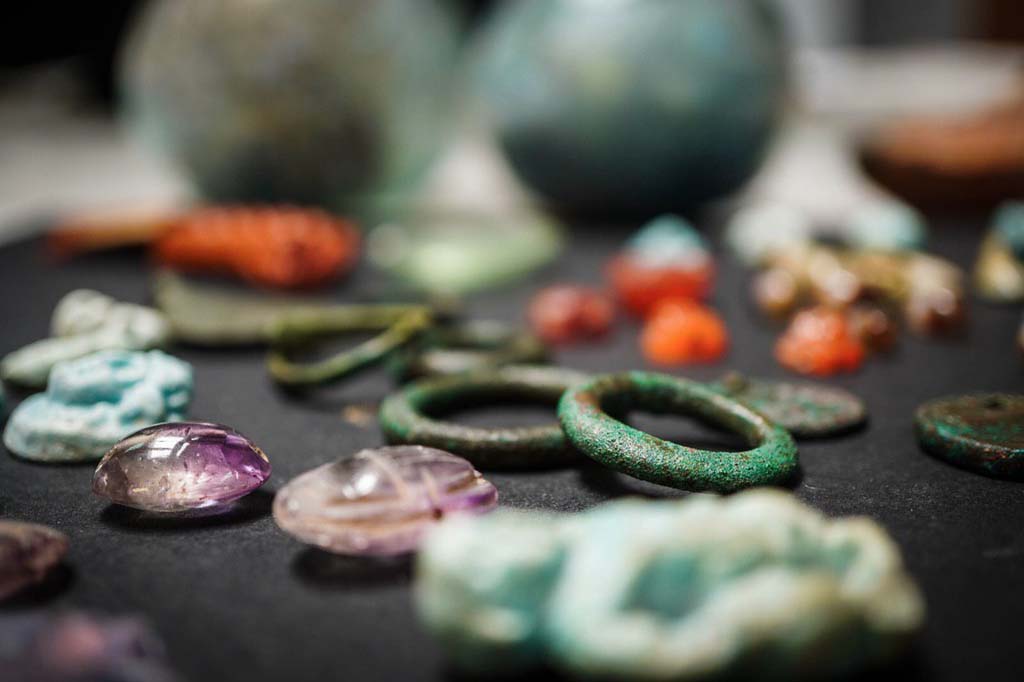 V.3 Pompeii. Casa del Giardino. August 2019. In the foreground scarab beetles in amethyst.

In primo piano gli scarabei in ametista.

Photograph © Cesare Abbate/ANSA courtesy Parco Archeologico di Pompei.
