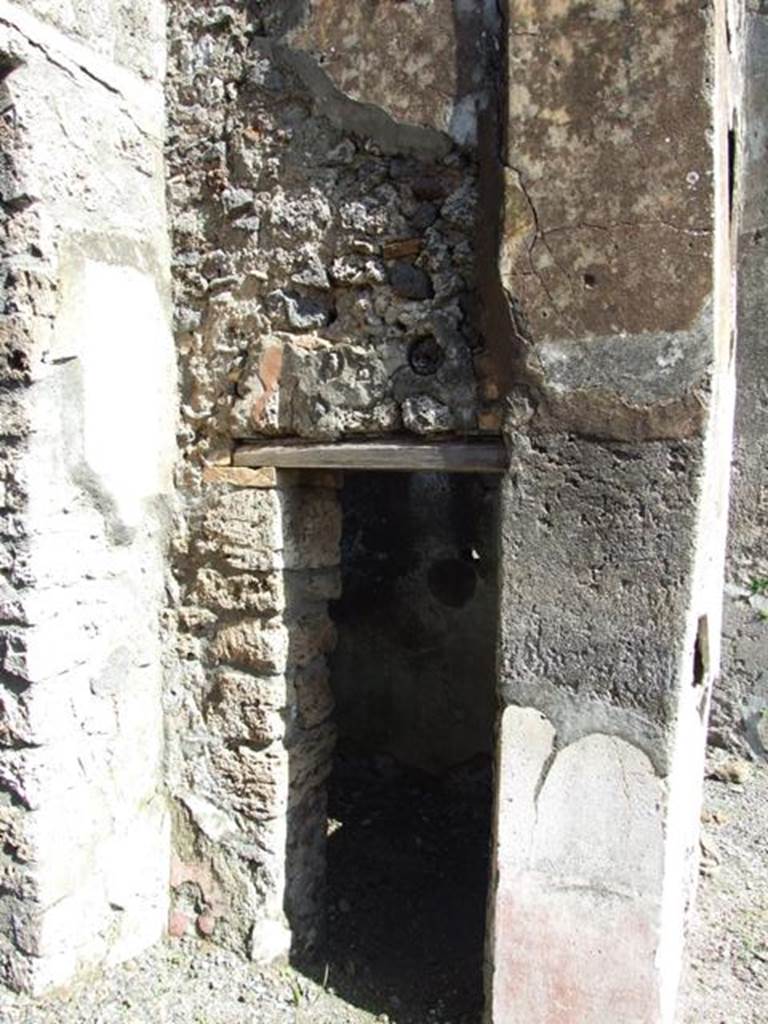 V.4.3 Pompeii. March 2009. Doorway to cupboard in north-east corner of atrium. West wall.
According to Boyce, items were found among the ruins of two cupboards in the room to the east of the atrium. They may have been found in this cupboard,  or else in the triclinium on the east side of the atrium (see part 1)? Together with a hoard of 130 silver and 54 bronze coins, also found were three bronze statuettes of the household gods. The Genius, and two Lares each holding cornucopia and patera and standing solidly on two feet. A marble statuette of Venus Anadyomene and a small marble altar may also have belonged to the shrine. He quoted Notizie degli Scavi di Antichit, 1899, 206. See Boyce G. K., 1937. Corpus of the Lararia of Pompeii. Rome: MAAR 14. (p.40, no.118, note 1). See Giacobello, F., 2008. Larari Pompeiani: Iconografia e culto dei Lari in ambito domestico.  Milano: LED Edizioni. (p.240).