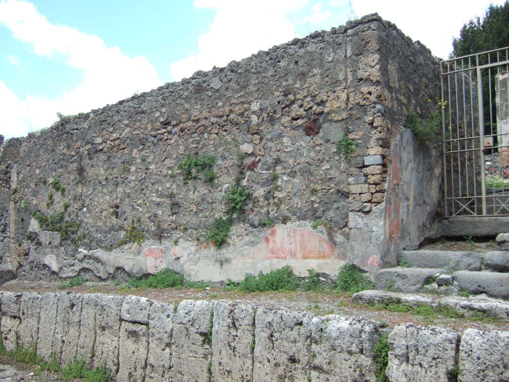 V.5.3 Pompeii. May 2006. High pavement and remains of painted plaster on wall to left of entrance.